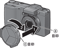 カメラ本体の目印（ａ）にレンズキャップの目印（ｃ）を合わせ、「カチッ」と音がする位置までレンズキャップを時計方向に回します
