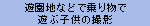 遊園地などで乗り物で遊ぶ子供の撮影