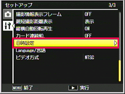 ADJ./OK ボタンを＞側に押した後、▲▼に押して、［ 日時設定 ］を選び＞側に押します